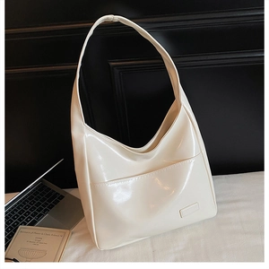 Detail of creamy white glossy leather tote bag with functional front pocket