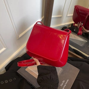 Glossy red leather flap shoulder bag with adjustable strap and premium texture
