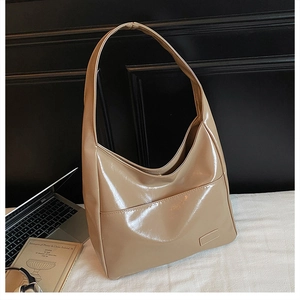 Detail of glossy beige PU leather tote bag with side pocket and side logo on soft fabric