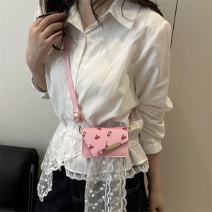 Mini sac à bandoulière rose avec imprimés cerises et lanière en cuir réglable