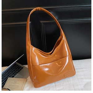 Detail of caramel glossy PU leather tote bag with functional front pocket and soft texture