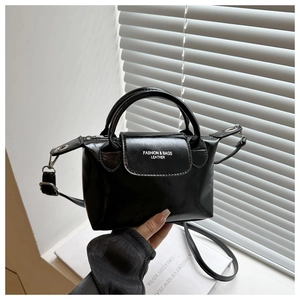 Detail of a black glossy handbag with Fashion & Bags lettering and silver hardware