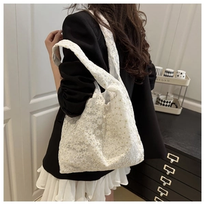 Detail of white daisy lace tote bag with delicate floral embroidery and sheer texture