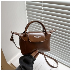 Detail showing the leather texture and elegant handle of this brown contrast mini bag
