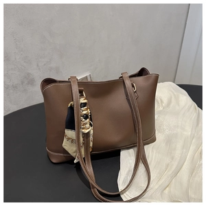 Detail of dark brown tote bag with white stitching and printed decorative silk scarf