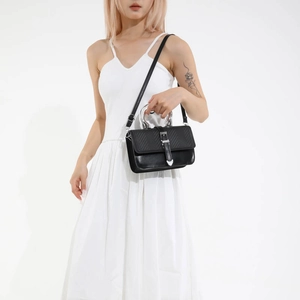 Black quilted leather shoulder bag with silver ring handle and heart detail shown on model