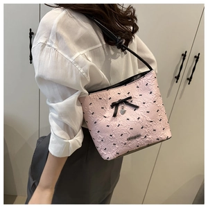 Detail of pink bow bucket bag with heart pendant and floral texture finish
