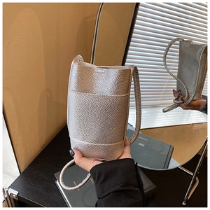Dettaglio della mini borsa a tracolla argento con trama granulata e cinturino sottile