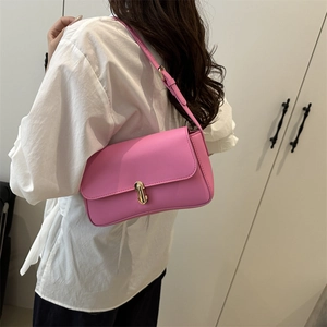 Pink rectangular leather shoulder bag with golden buckle shown on a model