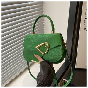 Detail view of vibrant green leather handbag with signature gold D-buckle hardware