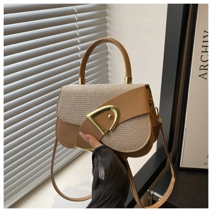 Close-up of brown leather and beige woven patchwork bag with a golden D-shaped buckle