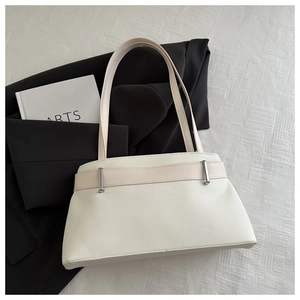 Détail de la texture grainée blanc cassé du sac à main avec ferrures métalliques argentées