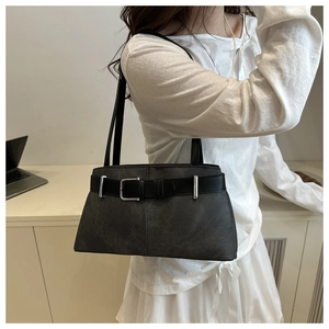 Détail d'un sac à bandoulière gris minimaliste avec sangle noire et boucle en métal argent