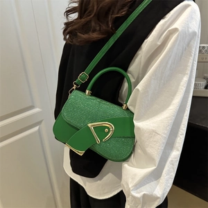 Green sequined saddle bag with gold D-buckle shown on model in a crossbody style