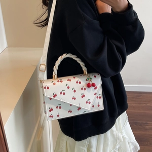 Sac à bandoulière blanc imprimé cerise avec poignée tissée porté par un mannequin