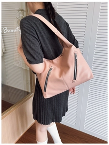 Detail of pink pebbled leather tote bag with functional silver zippers and wide shoulder strap