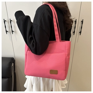 Detail view of the pink canvas tote bag showing the MS.HUIXIBAG leather logo patch