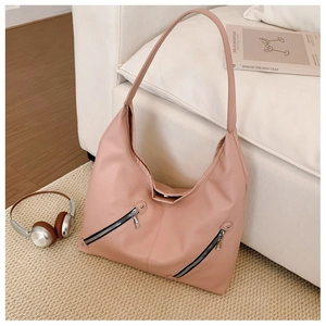 Pink lychee texture tote bag detail with dual decorative silver zippers on cream carpet