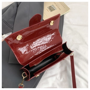 Detail view of burgundy patent leather bag interior with double magnetic closures