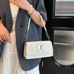 White quilted shoulder bag with silver butterfly charm and chain strap for women