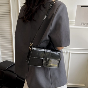 Elegant black patent leather crossbody bag for women with polished finish and metal hardware