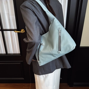 Light blue pebbled leather hobo tote bag with multiple decorative zipper pockets