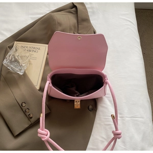 Vue détaillée de l'intérieur d'un sac baguette rose avec doublure brune et nœud chic