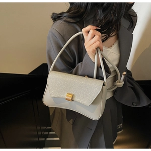 Détail du sac baguette en cuir gris avec rabat pailleté argent et boucle dorée