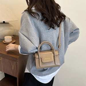 Minimalist beige crossbody square bag with top handle and fashion logo on the flap