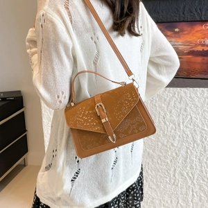 Brown faux leather crossbody bag with snake print flap and silver buckle on model