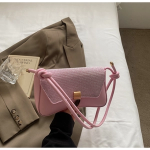 Détail du sac baguette rose avec rabat pailleté, fermoir doré et bandoulière nouée
