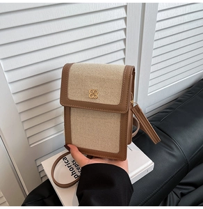 Gros plan détaillé du mini sac en toile et cuir avec un fermoir trèfle doré