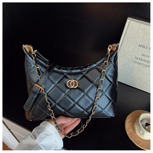 Detail of black quilted leather shoulder bag with gold chain and metal ring buckle
