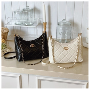 Detail of quilted leather texture and gold hardware on black and beige shoulder bags