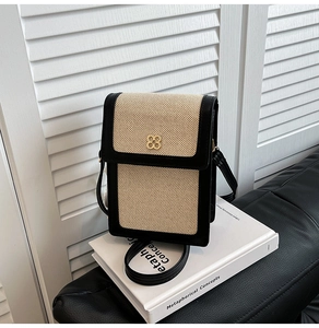 Détail d'un sac à bandoulière en paille tressée avec fermoir à fleur dorée