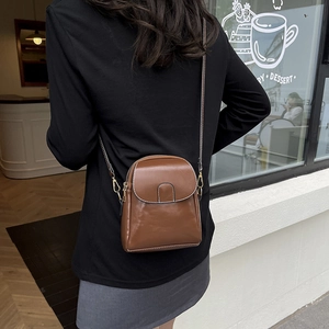 Brown vintage PU leather crossbody phone bag with gold hardware worn by model