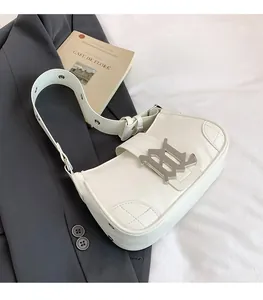Detail shot of a white PU baguette bag with a silver B-buckle on a gray suit