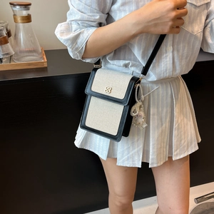 Sac bandoulière tendance en toile crème avec bordure en cuir noir et fermoir trèfle doré