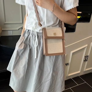 Sac bandoulière chic en toile beige et cuir marron avec logo floral en métal doré