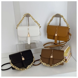 Detail of four retro flap bags in white, brown, and black with gold chain handles