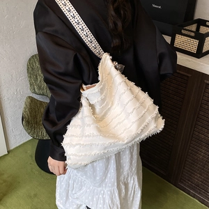 Bohemian white fringe tote bag with ethnic geometric strap shown as shoulder carry style