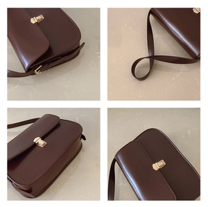 Detail view of dark brown leather crossbody bag with gold buckle and semi-circular base