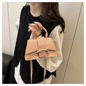 Detail of light pink lychee texture leather bag with unique double-hole buckle design