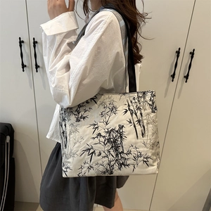 Sac fourre-tout à imprimé bambou chinois et bandoulière noire porté par un mannequin