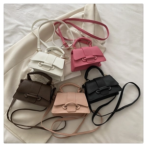 Detailed flat lay of textured mini crossbody bags in five colors with stylish props