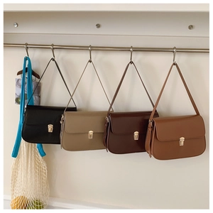 Detailed close-up of retro shoulder bags in black, beige, and brown with gold metal locks