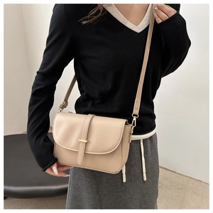 Detail of high-quality leather shoulder bag featuring a golden metal buckle closure
