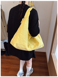 Détail d'un sac cabas demi-lune jaune à grande capacité montrant la texture nylon
