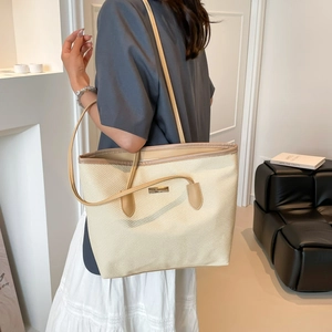 Minimalist beige woven tote bag with brown leather handles for women's daily commute