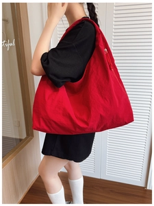 Grand sac fourre-tout rouge en nylon porté par un mannequin pour le trajet quotidien